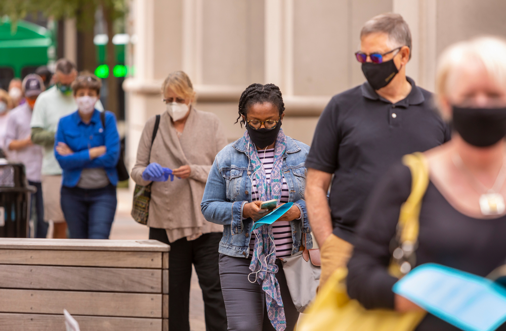 people standing in line outside with masks on