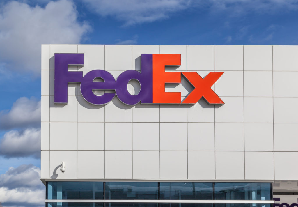side of a large gray building with a FedEx logo sign